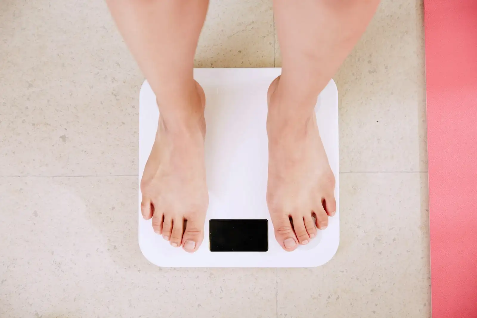 Person standing barefoot on a weight scale.