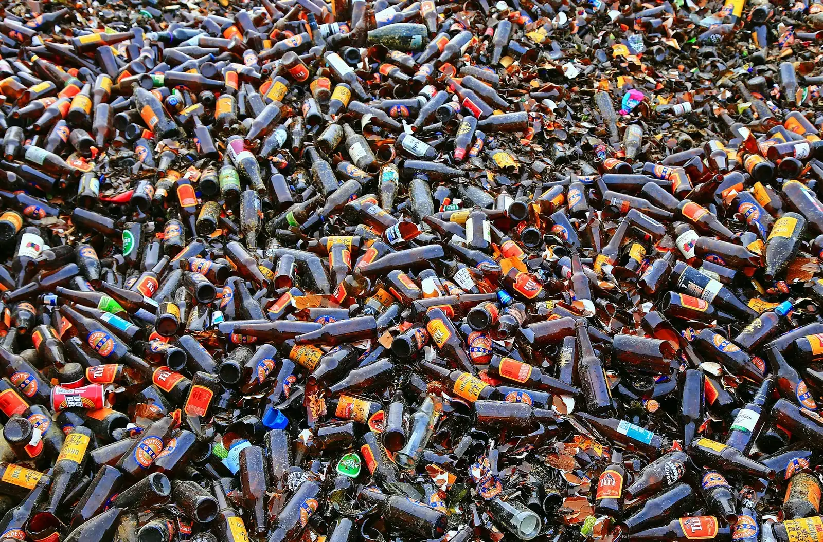 Multiple broken beer bottles on the ground represent the problems associated with alcohol dependence.